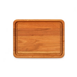 A rectangular wooden cutting board with rounded corners and a raised rim, shown from a top-down view on a solid white background.