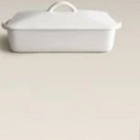 White ceramic baking dish with a lid on a white background