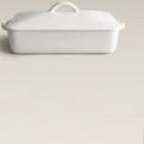 White ceramic baking dish with a lid on a white background