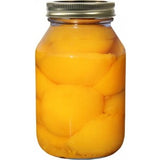 Jar of preserved peaches on a white background