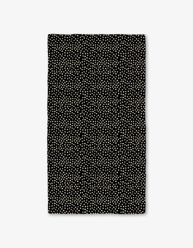 A black bath towel with a white geometric pattern.
