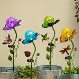 A solar lighted metal stake featuring a floral design with a purple, blue, and yellow globe at the top, mounted on a green stem with butterflies and ladybugs.