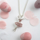 Necklace with a ballerina pendant on a white background with pink stones.