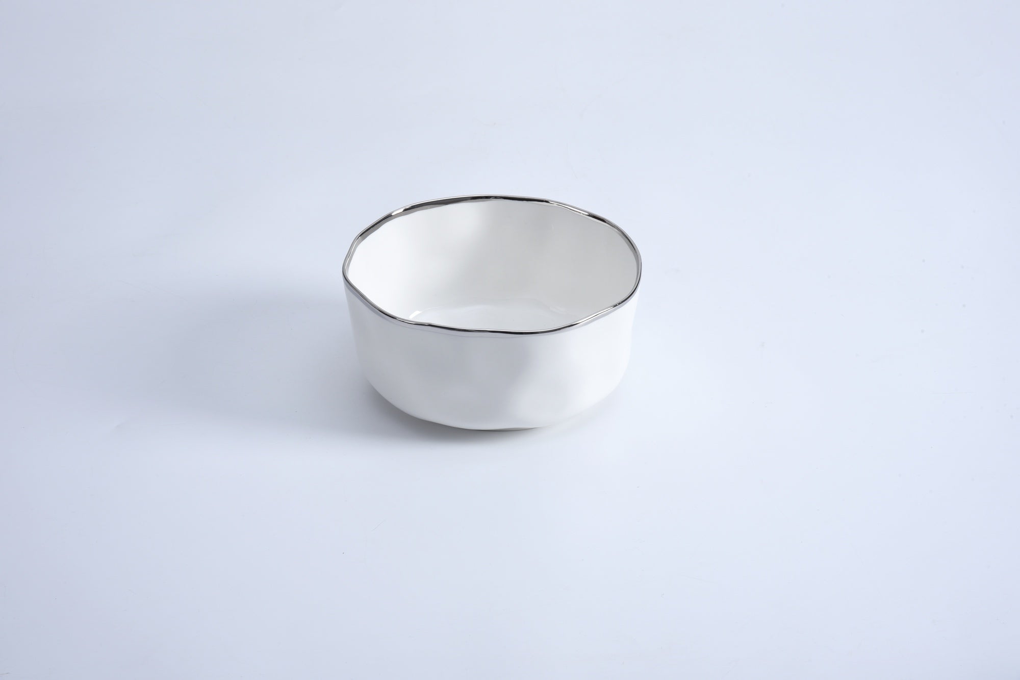 A white ceramic bowl with a black rim on a light background.