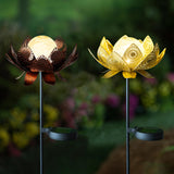 Two decorative garden stakes with lotus-shaped tops, one with a bronze finish and the other with a gold finish, set against a blurred garden background.