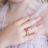Close-up of a hand wearing a colorful ring with a soft background
