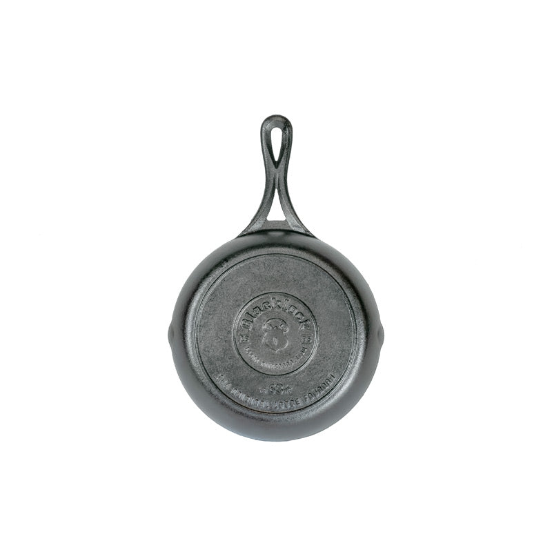 A black 7 inch cast iron skillet with a handle, viewed from the bottom.