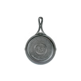 A black 7 inch cast iron skillet with a handle, viewed from the bottom.