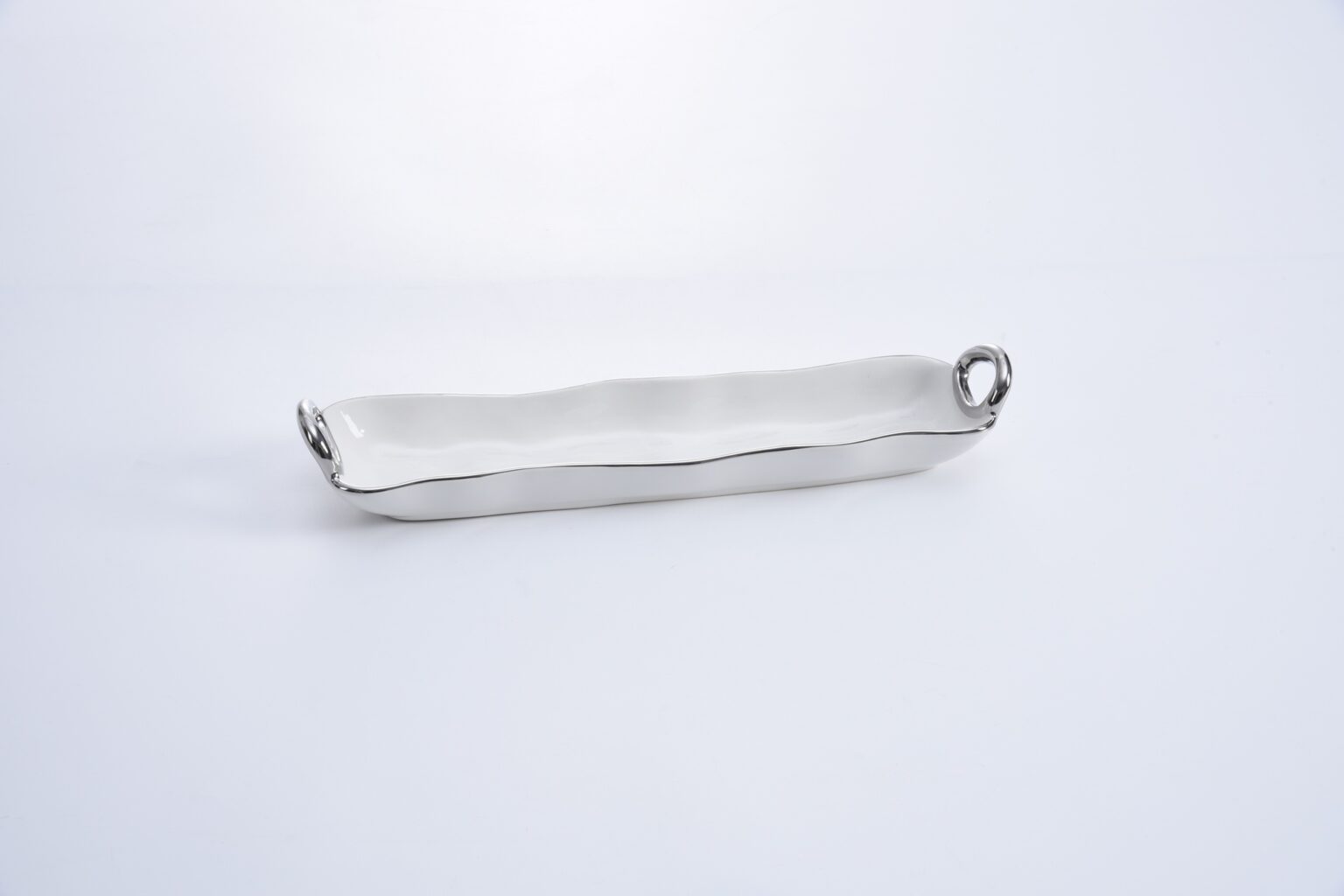 A silver cracker tray with a sleek design, featuring a long rectangular body with raised edges and two round handles on the sides.