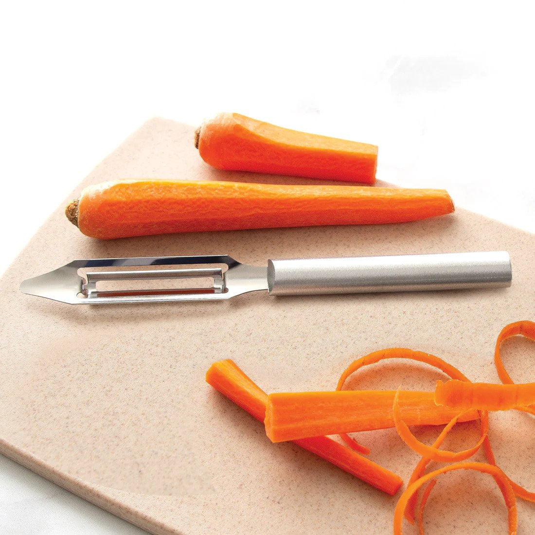A stainless steel vegetable peeler with a swiveling blade and a silver satin aluminum handle, displayed next to a carrot and a pair of orange-handled peelers.