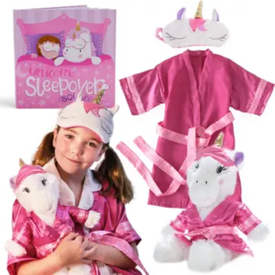 A collection of unicorn-themed sleepover gifts for kids stuffed animals,including a pink unicorn robe, a sleep mask, a plush unicorn toy, and a unicorn horn hair accessory, presented with a smiling girl modeling the items.