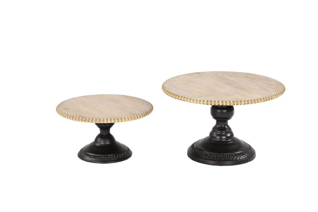 A two-tier cake stand with a marble top and black metal legs, the lower tier is black and the upper tier is gold.