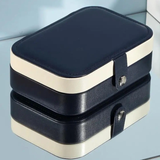 A portable black and beige travel jewelry organizer with snap closure.