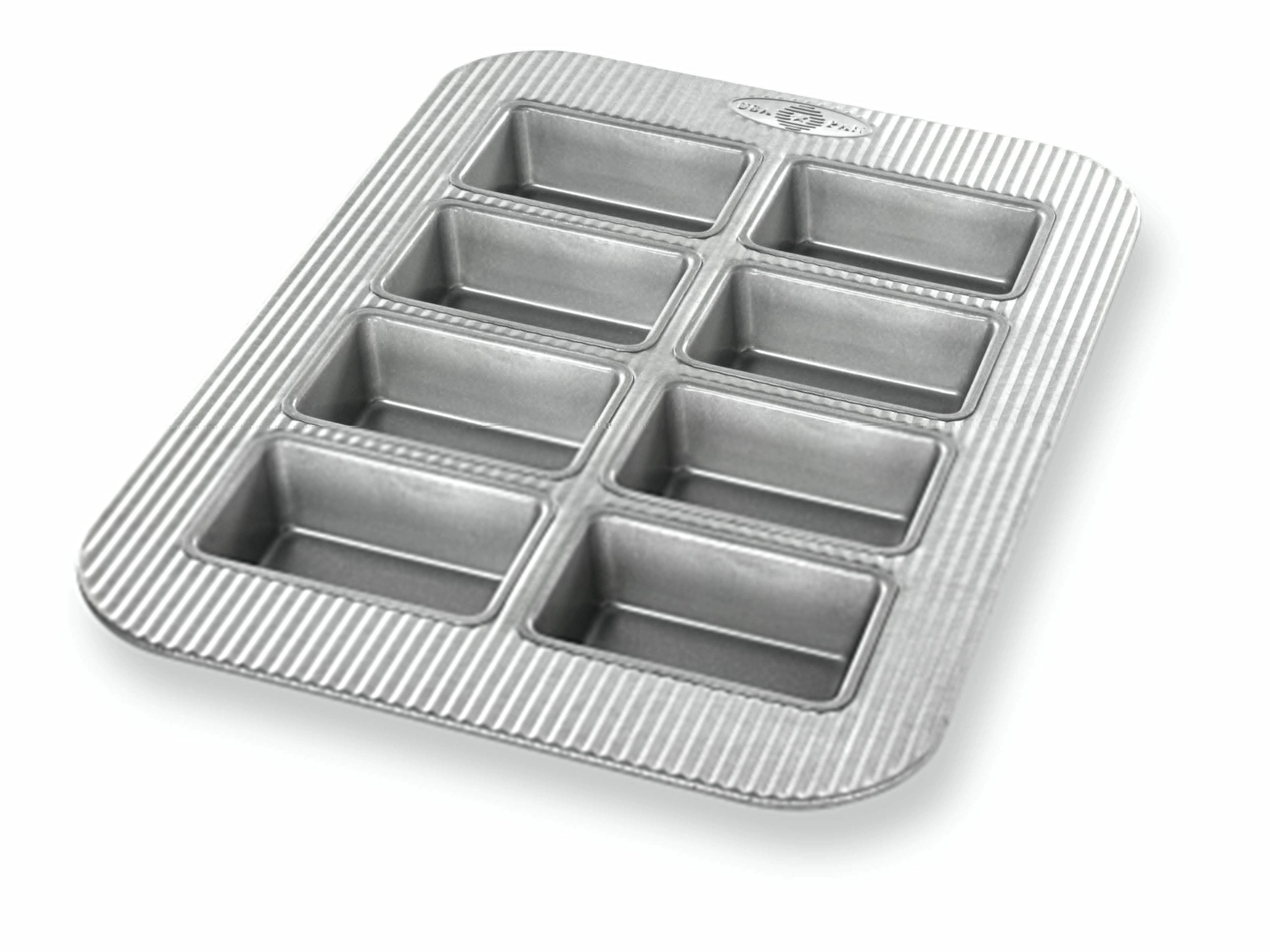 A silver mini loaf pan with eight sections, each lined with a non-stick material.