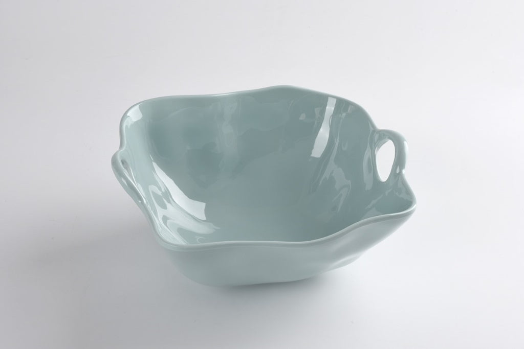 A large blue ceramic bowl with a curved edge on a white background.