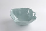 A large blue ceramic bowl with a curved edge on a white background.