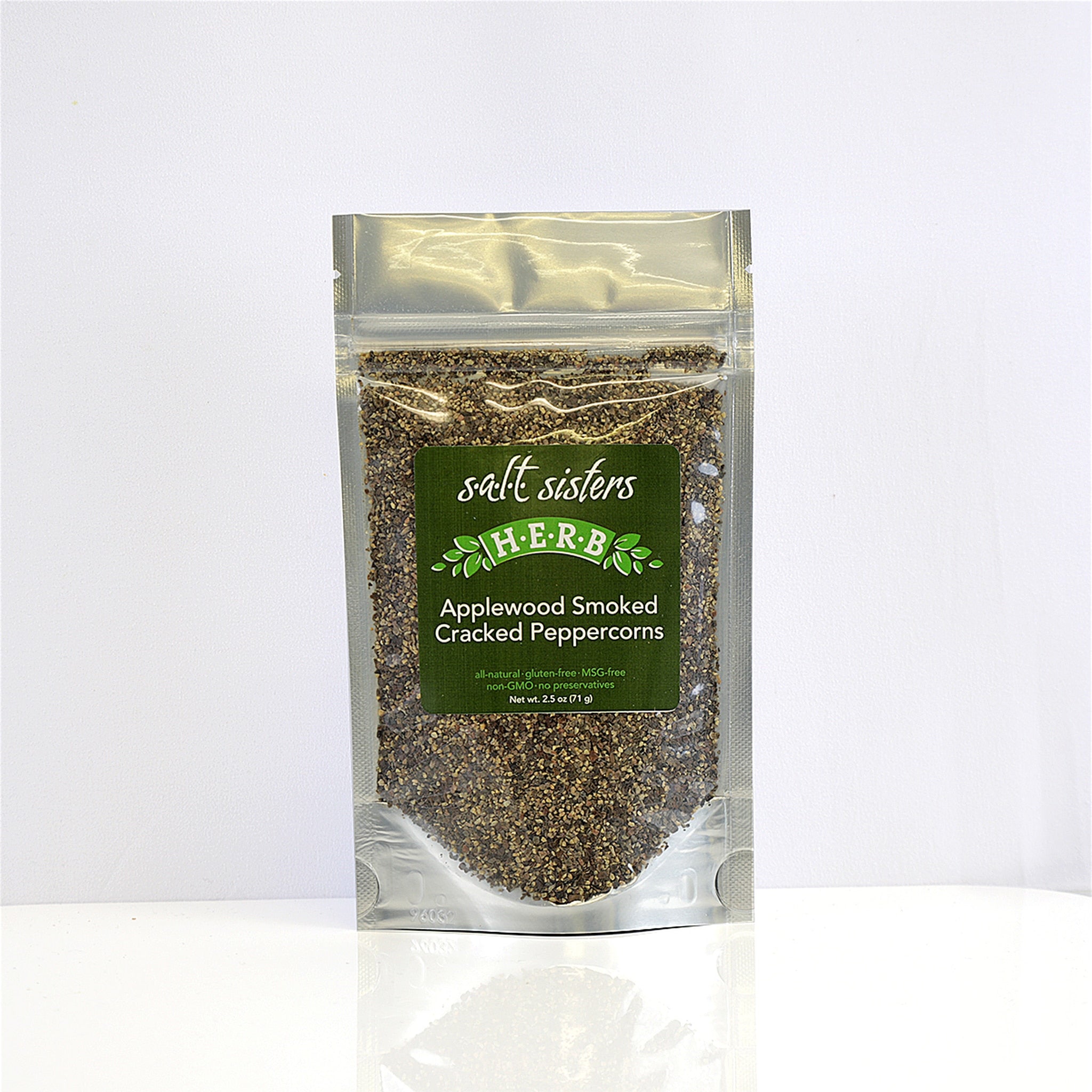 A clear plastic packet of Salt Sisters Herb-Applewood Smoked Chili Flakes, with the product visible through the transparent front of the packet.
