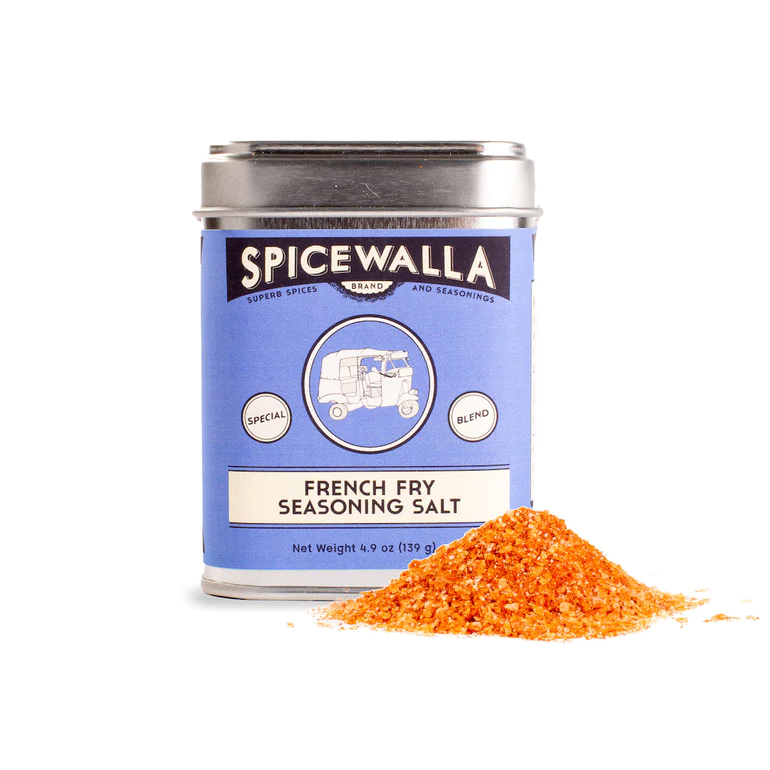 A tin can labeled 'SPICEWALLA French Fry Seasoning Salt' with a pile of orange seasoning salt in front of it.