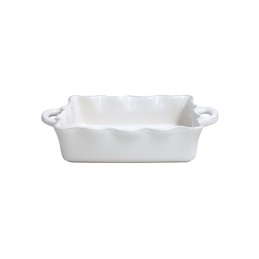 A white rectangular ceramic baker with ruffled edges and two handles.