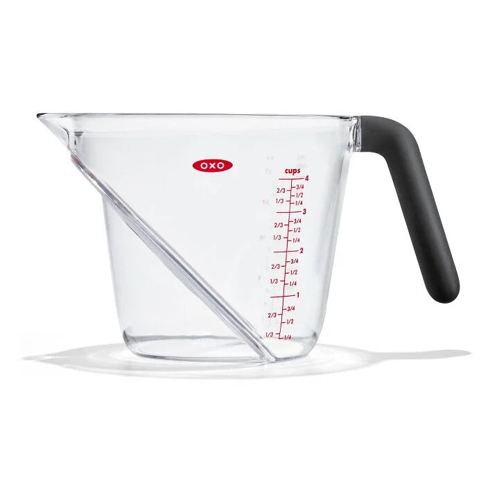 Clear measuring cup with black handle and red measurement markings on a white background