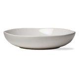 A white, round ceramic pasta bowl with a deep design.
