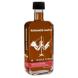 A bottle of Runamok Maple Syrup with 'Festivus infused' text on the label, indicating a flavored maple syrup with cinnamon, ginger, nutmeg, vanilla, and clove.