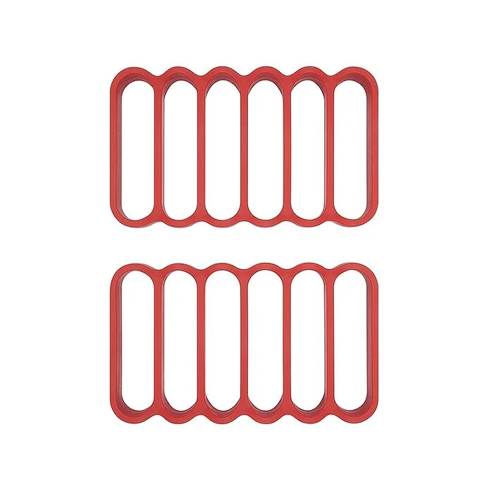 Two red silicone roasting racks with multiple compartments, designed for use in cooking.