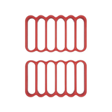 Two red silicone roasting racks with multiple compartments, designed for use in cooking.