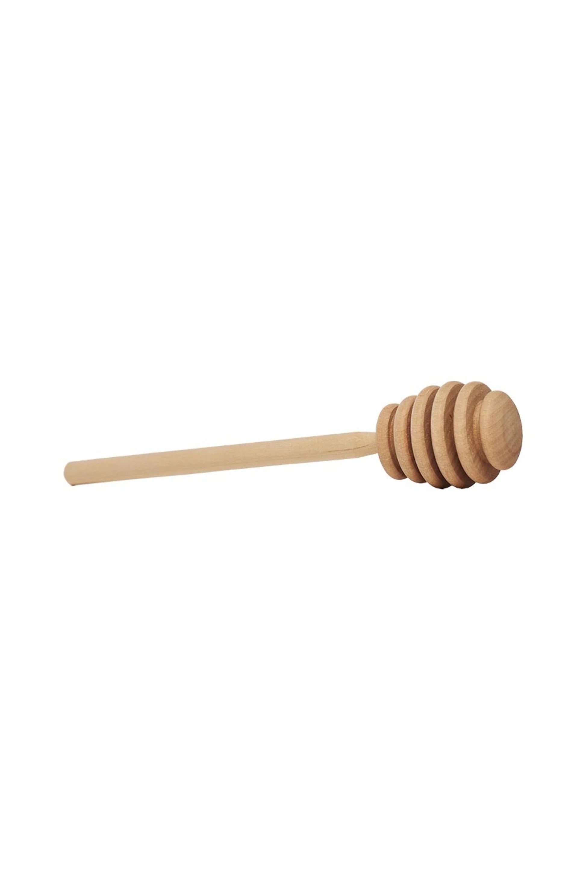 A wooden honey dipper with a hexagonal honeycomb design at the end.