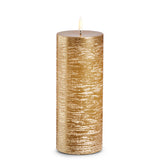 A rustic gold pillar candle with a textured finish, showing a warm gold color.