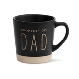 A black ceramic mug with the text 'PROPERTY OF DAD' printed in capital letters on the front.