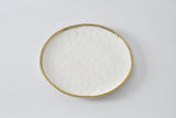 A round white dinner plate with a gold rim.