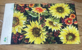 An embossed floor mat with a floral pattern, featuring large sunflowers, placed on a wooden floor.