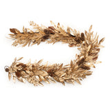 A dried bay leaf garland laid out on a white background.