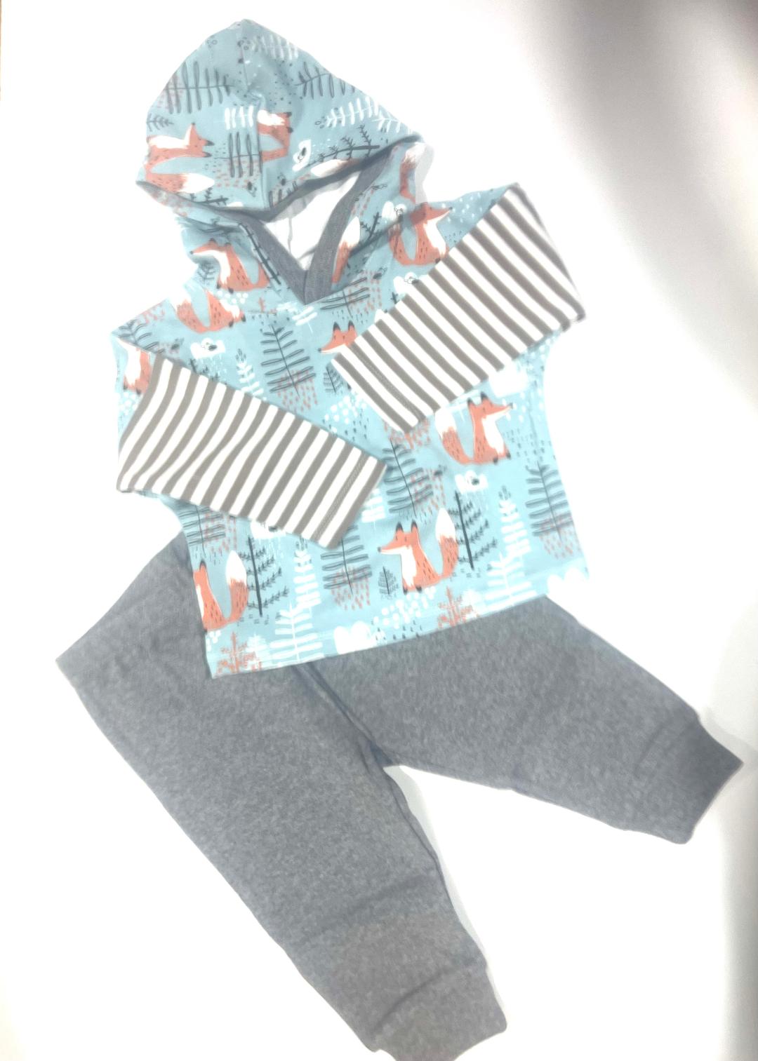 A set of children's clothing, with the top featuring a fox pattern and stripes, and the pants in gray color.