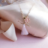 Necklace with a delicate pendant on a soft pink fabric background