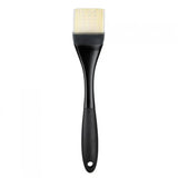 A large OXO silicone basting brush with a black handle and white bristles.