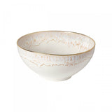 A white ceramic serving bowl with a geometric pattern and gold accents on the rim.