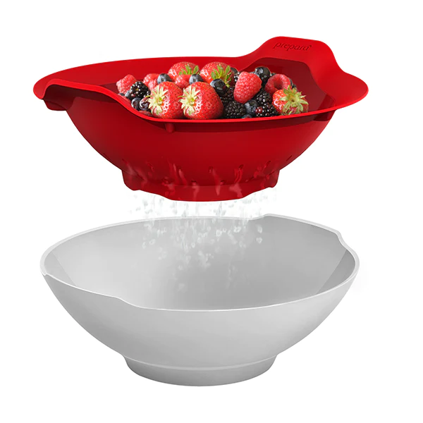 A red bowl designed for presenting fresh berries, with a lid that appears to be made of the same material as the bowl. The bowl is shown with a selection of berries inside, and water is sprinkling out from the bowl, suggesting the freshness of the berries.
