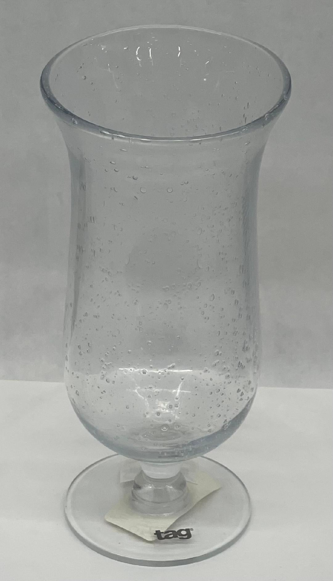 A clear tall frozen drink glass with a bubble pattern.