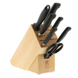 A set of knives with black handles and a wooden knife block.