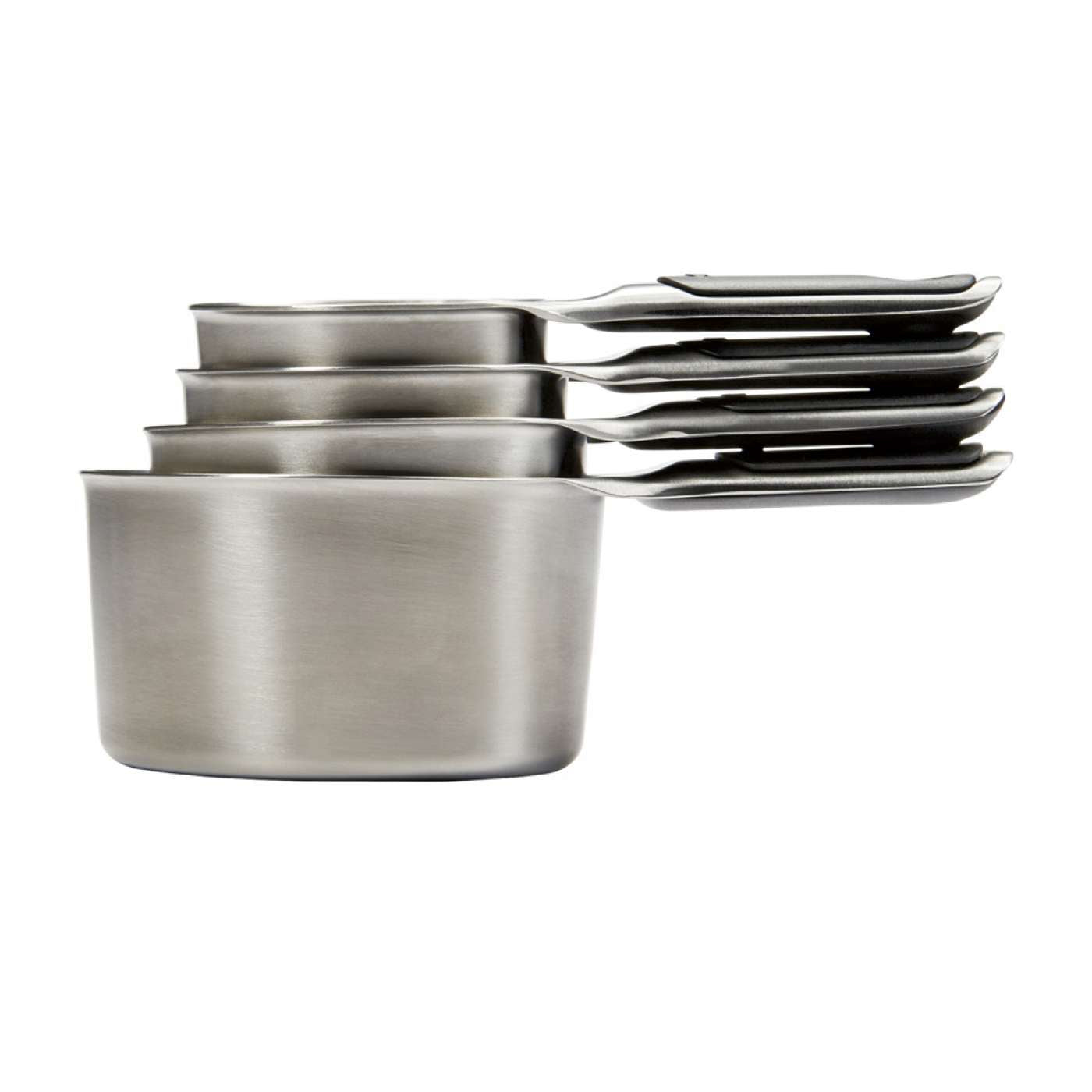 A set of four stainless steel measuring cups stacked together.