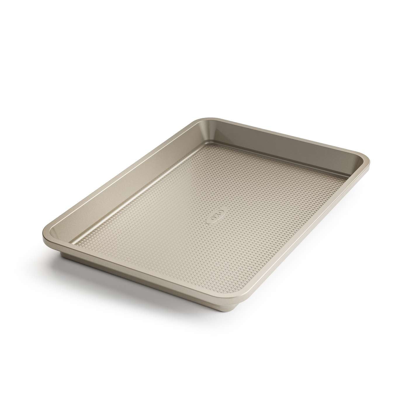 A beige non-stick quarter sheet baking pan with micro-textured surface, branded by OXO.