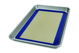 A silver half sheet pan with a beige baking mat placed in the center.