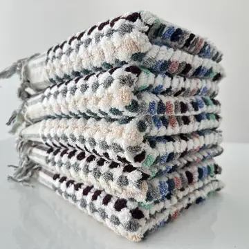 A stack of multicolored hand towels with a geometric pattern.