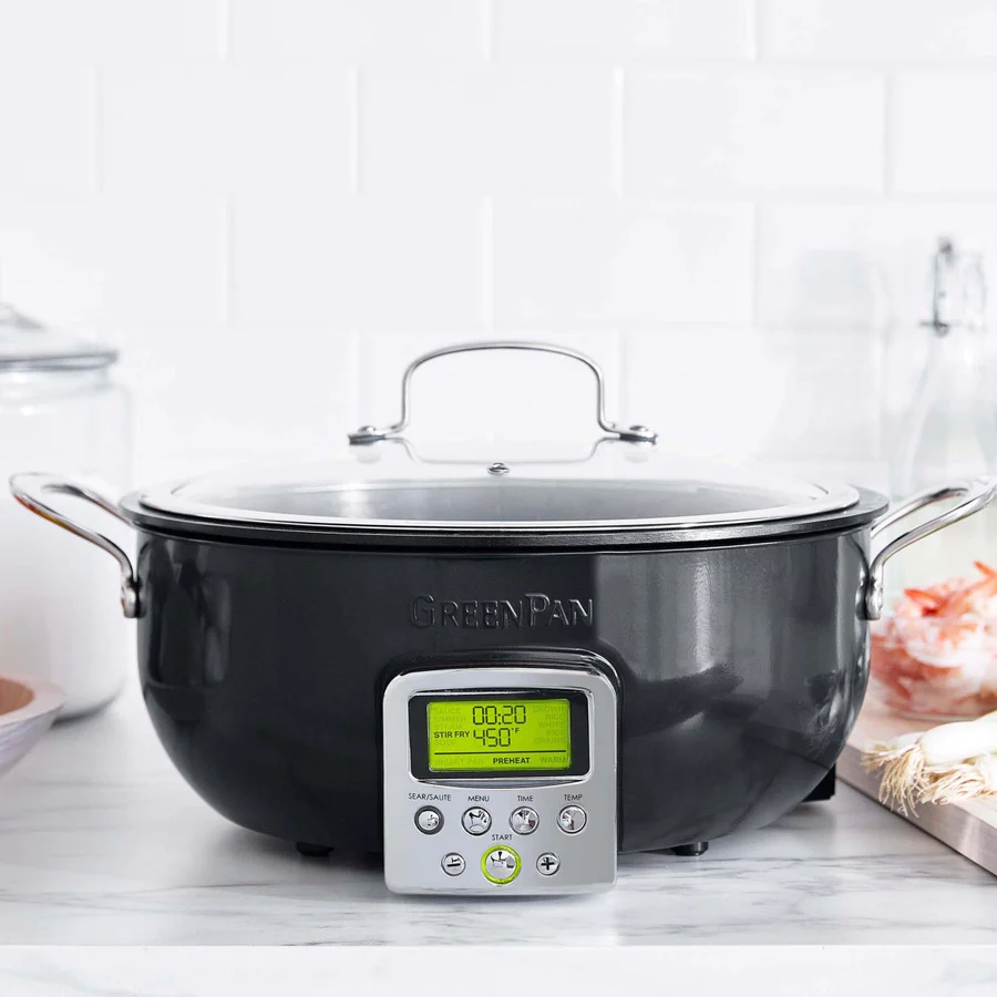 A digital smart skillet with a black exterior and a digital display panel on the front, set on a kitchen counter.