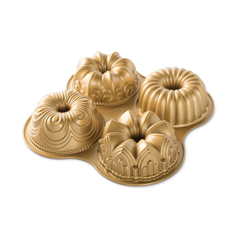 A set of four gold-colored bundt cake pans arranged in a quartet formation, showcasing their ornate designs.