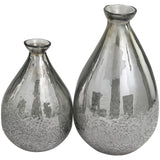 A pair of handcrafted glass vases with a geometric design, one larger than the other, both with a solid pattern and reflective surface.