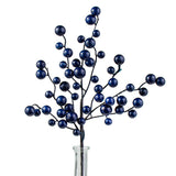 Artificial navy blue berry branch decor with glossy dark blue round berries on thin dark stems, displayed in a clear glass vase against a white background.