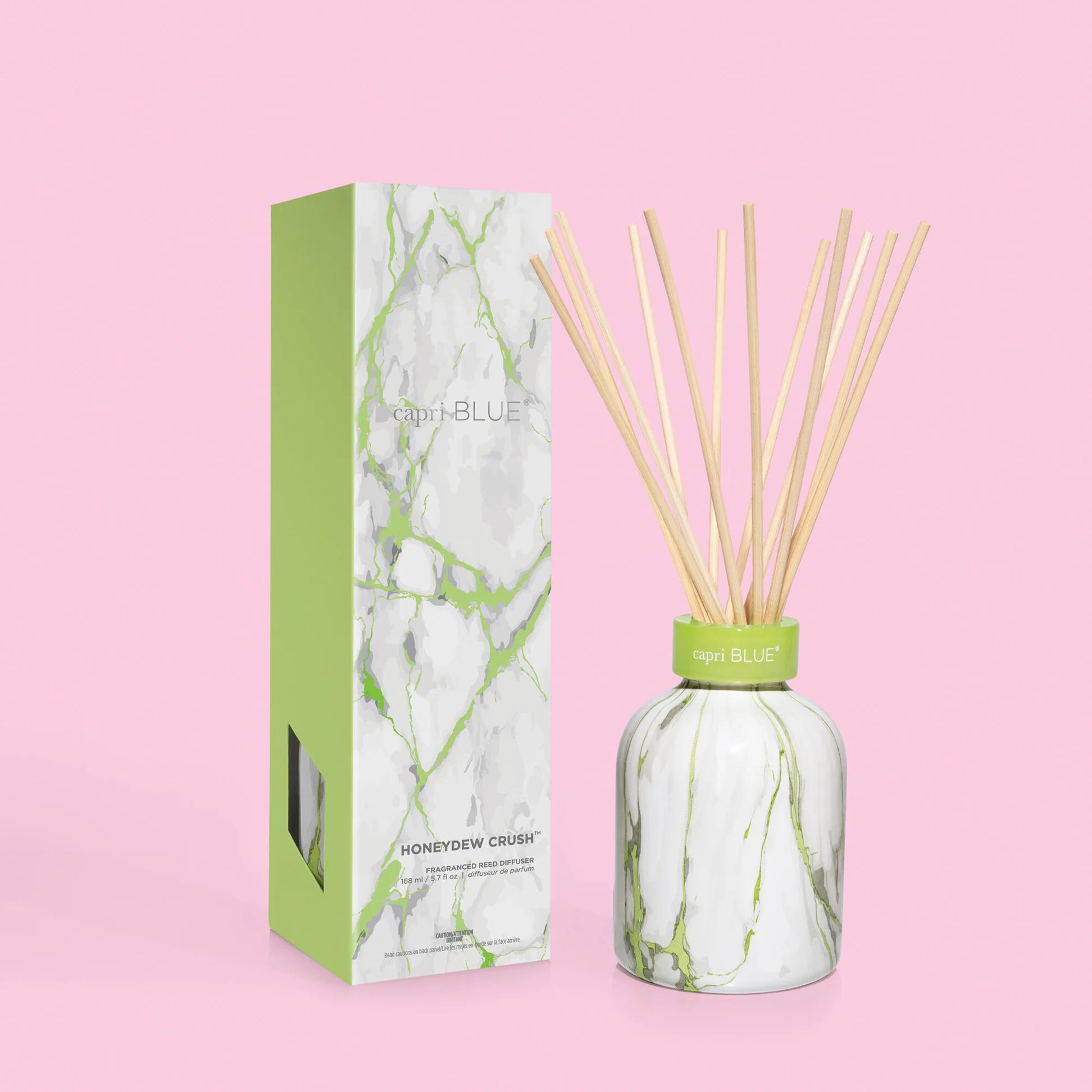 A reed diffuser with clear bottle and gold accents, accompanied by packaging with a window displaying the product.